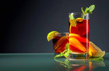 Cam bir masada limon, limon ve nane içeren kokteyller.