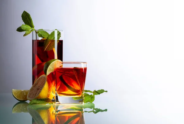 Cocktails with lime, lemon and mint on a glass table. — Stock Photo, Image