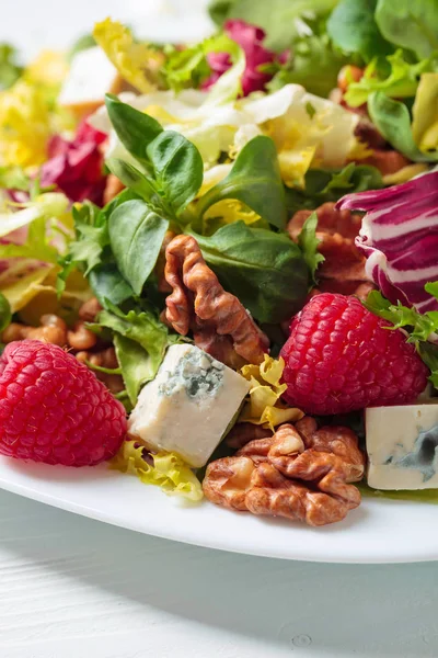 Зеленый салат с ломтиками голубого сыра, малины и орехов . — стоковое фото