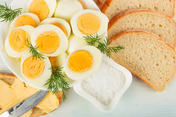 Boiled eggs with bread, butter and dill. — Stock Photo, Image