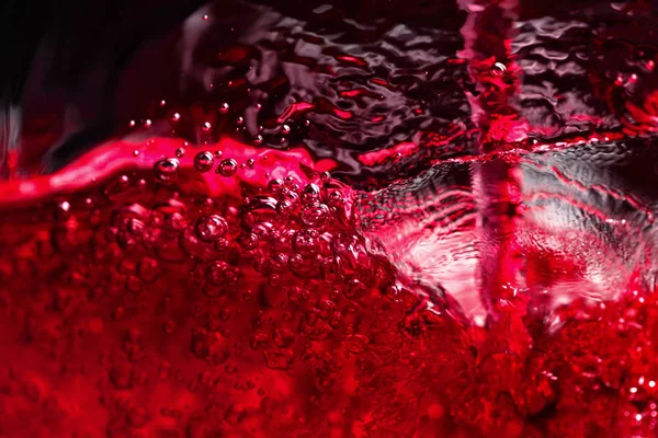 Rotwein auf schwarzem Hintergrund, abstraktes Spritzen. — Stockfoto