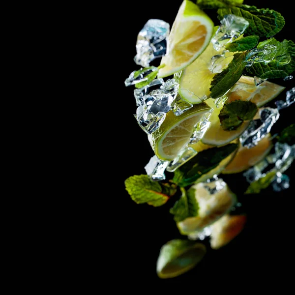 Menta, fette di lime e ghiaccio sul tavolo di vetro, vista dal basso . — Foto Stock