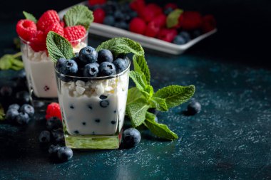 Kremalı kremalı tatlı, ahududu ve yaban mersini süslenmiş zekâ