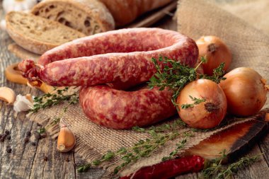 Eski ahşap bir masada ekmek ve baharat ile kuru-tedavi sosis.