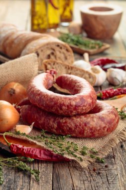 Eski ahşap bir masada ekmek ve baharat ile kuru-tedavi sosis.