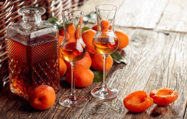 Kayısı likörü ve taze kayısı eski ahşap bir masada.  