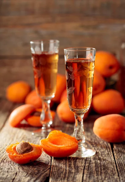 Aprikot minuman keras dan aprikot segar di atas meja kayu tua . — Stok Foto