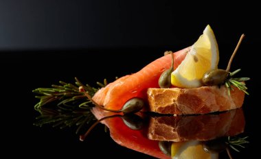 Alabalar, limon dilim, kapanlar ve biberiye ile sandviç.