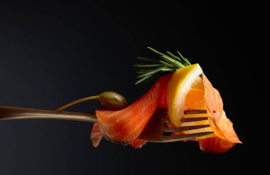Alabalık filetosu, limon dilim, Kapari ve biberiye.