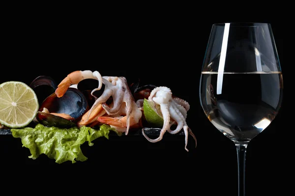 Copa de vino blanco y mariscos deliciosos mezclados . — Foto de Stock