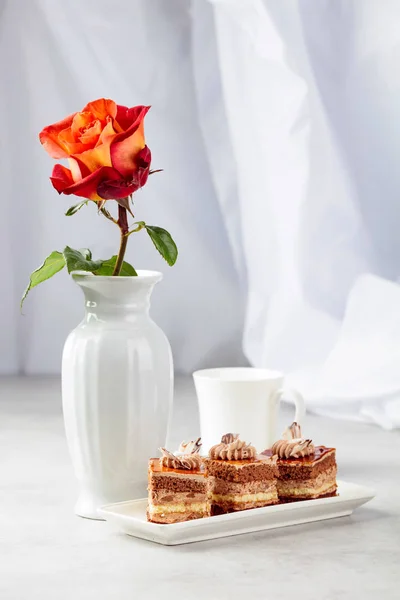 Pasteles en capas con rosa en una mesa de marmorea blanca . —  Fotos de Stock