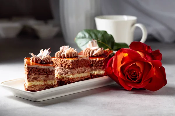 Gelaagde taarten met roos op een witte marmorean tafel. — Stockfoto