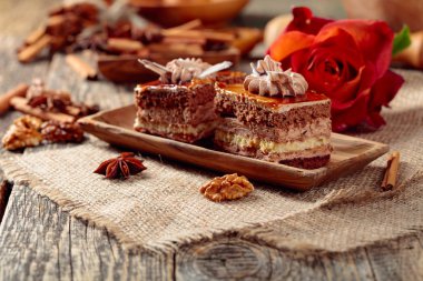 Eski ahşap masada baharatlar ve fındık ile katmanlı kekler. 