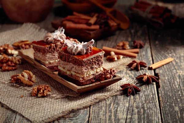 Gâteaux en couches avec des épices et des noix sur une table en bois . — Photo