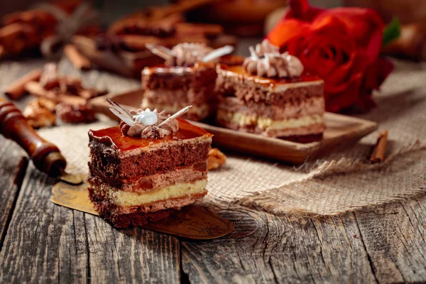 Geschichtete Kuchen mit Gewürzen und Nüssen auf einem alten Holztisch. — Stockfoto