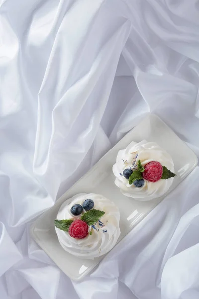 Dessert pavlova mit Himbeeren, Blaubeeren und Minze auf weißem — Stockfoto