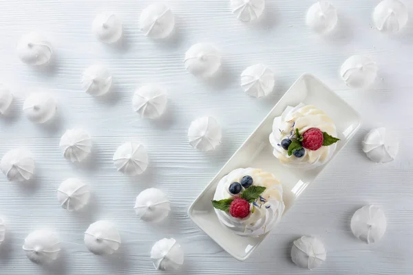 Dessert pavlova mit Himbeeren, Blaubeeren und Minze auf weißem — Stockfoto