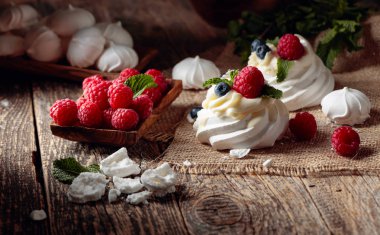 Dessert Pavlova with raspberries, blueberries and mint on a old  clipart