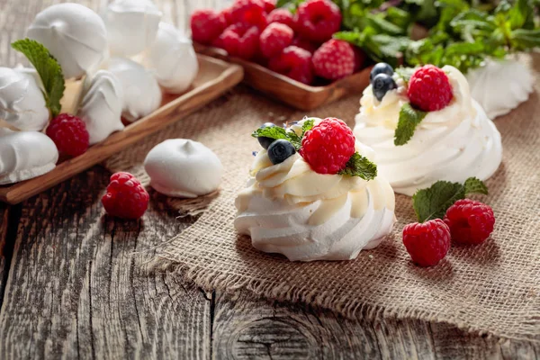 Dessert pavlova mit Himbeeren, Blaubeeren und Minze auf einem alten — Stockfoto