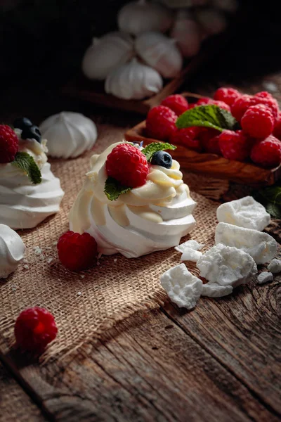 Dessert pavlova mit Himbeeren, Blaubeeren und Minze auf einem alten — Stockfoto