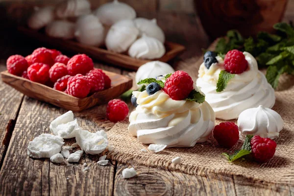 Dessert pavlova mit Himbeeren, Blaubeeren und Minze auf einem alten — Stockfoto