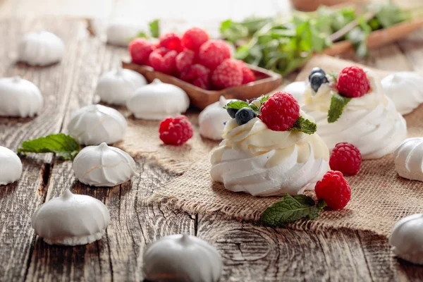 Dessert pavlova mit Himbeeren, Blaubeeren und Minze auf einem alten — Stockfoto