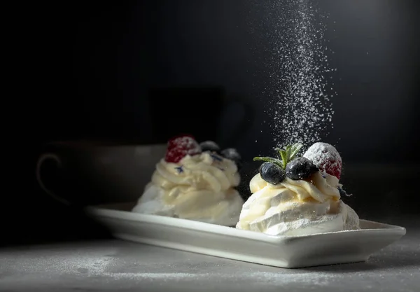 Dessert Pavlova  sprinkled with powdered sugar. — Stock Photo, Image