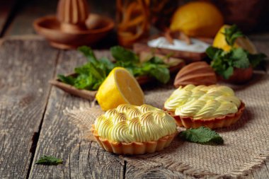 Eski ahşap bir masada limon kremalı ve nane şekerli tart. 
