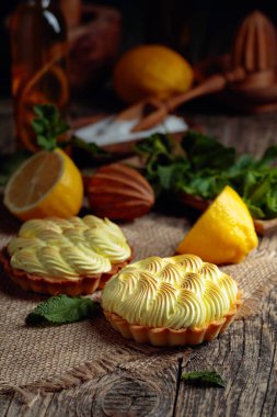Eski ahşap bir masada limon kremalı ve nane şekerli tart. 