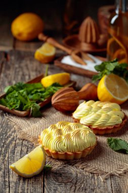 Eski ahşap bir masada limon kremalı ve nane şekerli tart. 