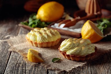 Eski ahşap bir masada limon kremalı ve nane şekerli tart. 