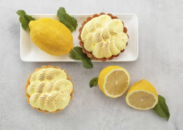 Beyaz bir masada limon kremave nane ile Tartlets. 