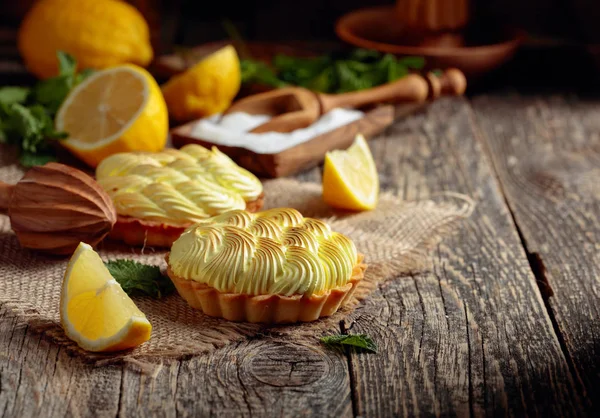 Tartelettes à la crème au citron et menthe sur une vieille table en bois . — Photo