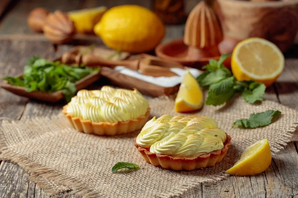 Eski ahşap bir masada limon kremalı ve nane şekerli tart. 