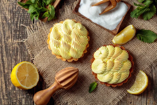 Eski ahşap bir masada limon kremalı ve nane şekerli tart. 