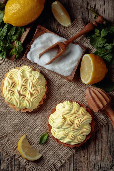 Eski ahşap bir masada limon kremalı ve nane şekerli tart. 