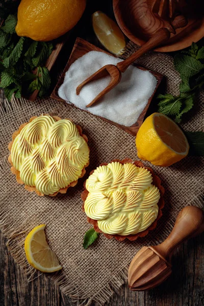 Eski ahşap bir masada limon kremalı ve nane şekerli tart. 