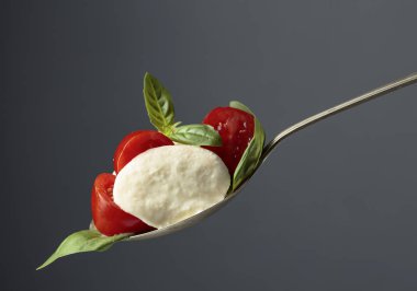 Mozzarella koyu bir arka plan üzerinde domates ve fesleğen ile. 
