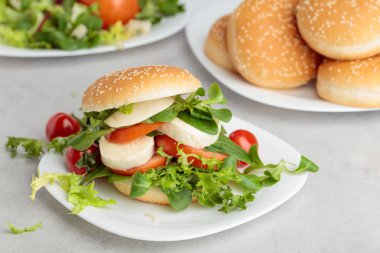 Mozzarella peyniri, domates, salata mutfak masasında ile sandviç.