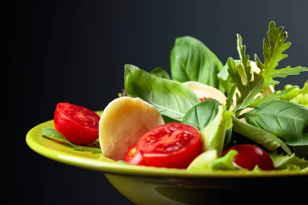Green salad with mozzarella, tomato, basil and olive oil in gree — Stock Photo, Image