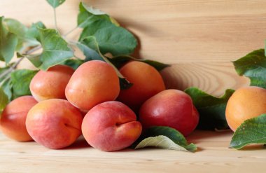 Ahşap bir masa üzerinde yaprakları ile Kayısı.