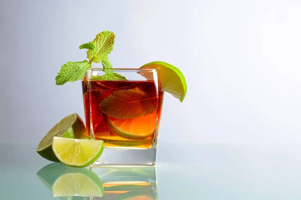 Cold tea with lime and mint on a glass table. — Stock Photo, Image