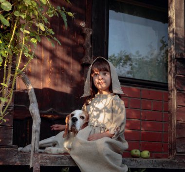 Eski evin yakınında bir yaz akşamı bir köpek ile küçük kız.