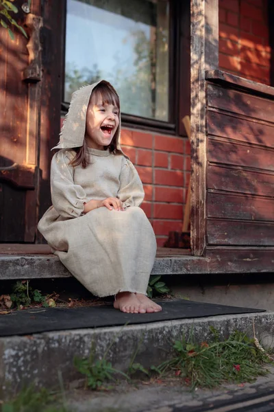 Little  barefoot girl in a old canvas dress on the threshold of — Stock Photo, Image