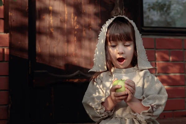 Girl with apple on a summer evening near the old house. — Stock Photo, Image