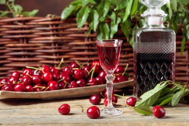 Ahşap bir TABL üzerinde ahşap bir kase kiraz likör ve kırmızı kiraz