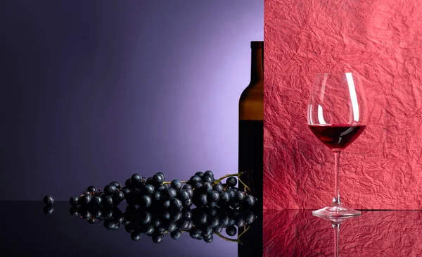 黒テーブルの上に赤ワインのボトルとガラス. — ストック写真