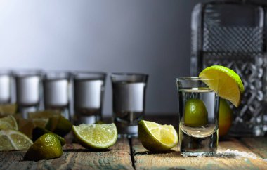 Eski ahşap arka planda tuz ve kireç ile tekila.