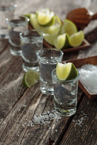 Tequila con sale e calce su un vecchio fondo di legno . — Foto Stock