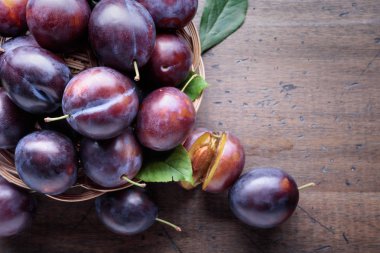 Ahşap arka plan üzerinde olgunlaşmış sulu Erik. 